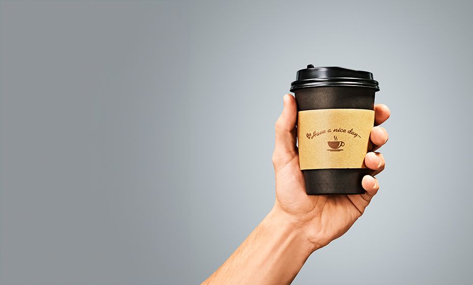 A hand holding a cup of coffee representing the convenience retail industry