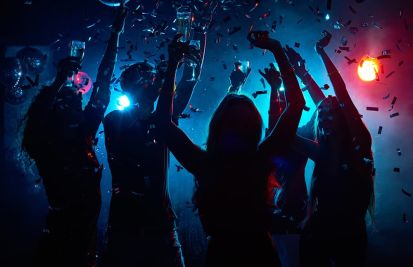 Young people with raised glasses having fun and clubbing