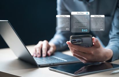 recurring billing with man holding a mobile and typing on laptop