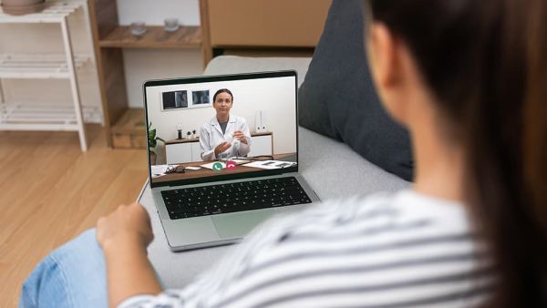 Patient on a laptop having a telehealth call with a doctor