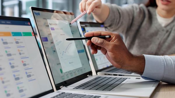 Business owners on laptop looking at payment reports