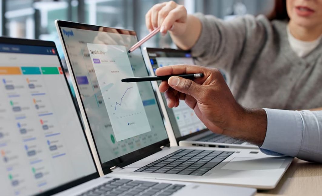 Business owners on laptop looking at payment reports