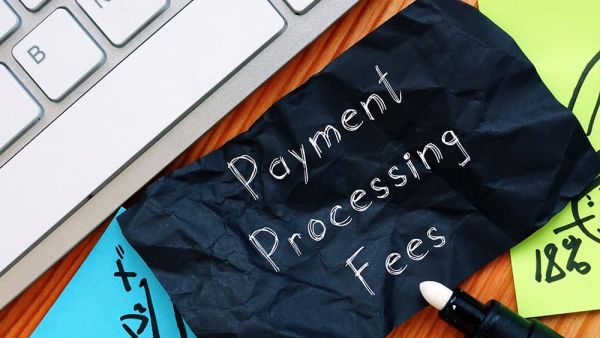 payment processing fees on paper next to laptop
