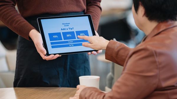 staff getting a tip from customer in restaurant