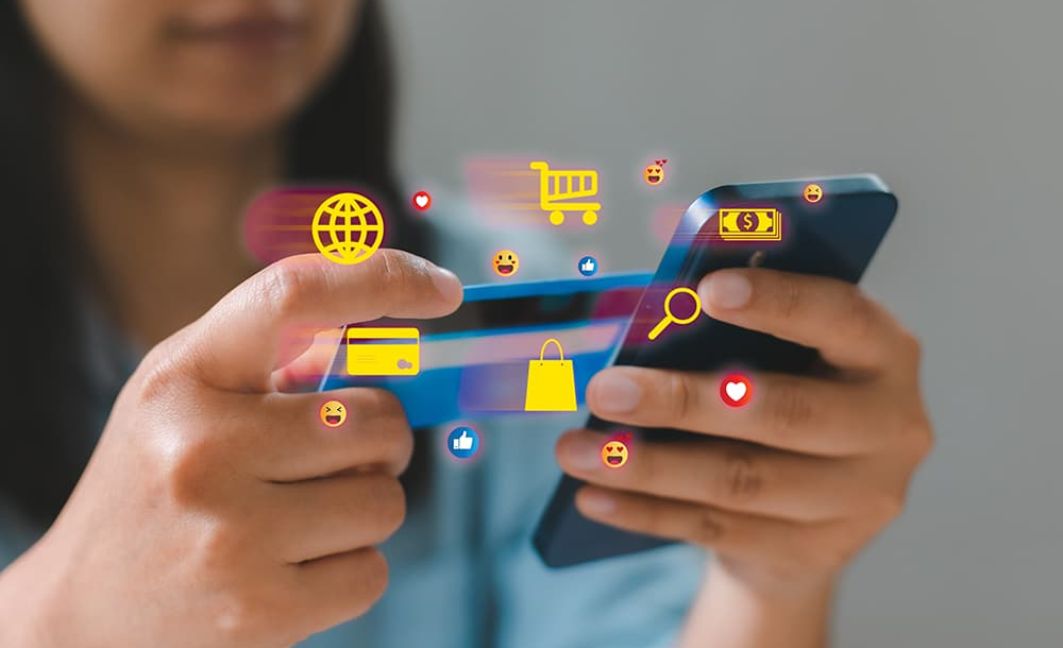 Woman on phone making purchases online with her credit card