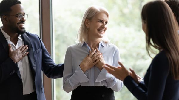 Employees celebrating colleague achievement