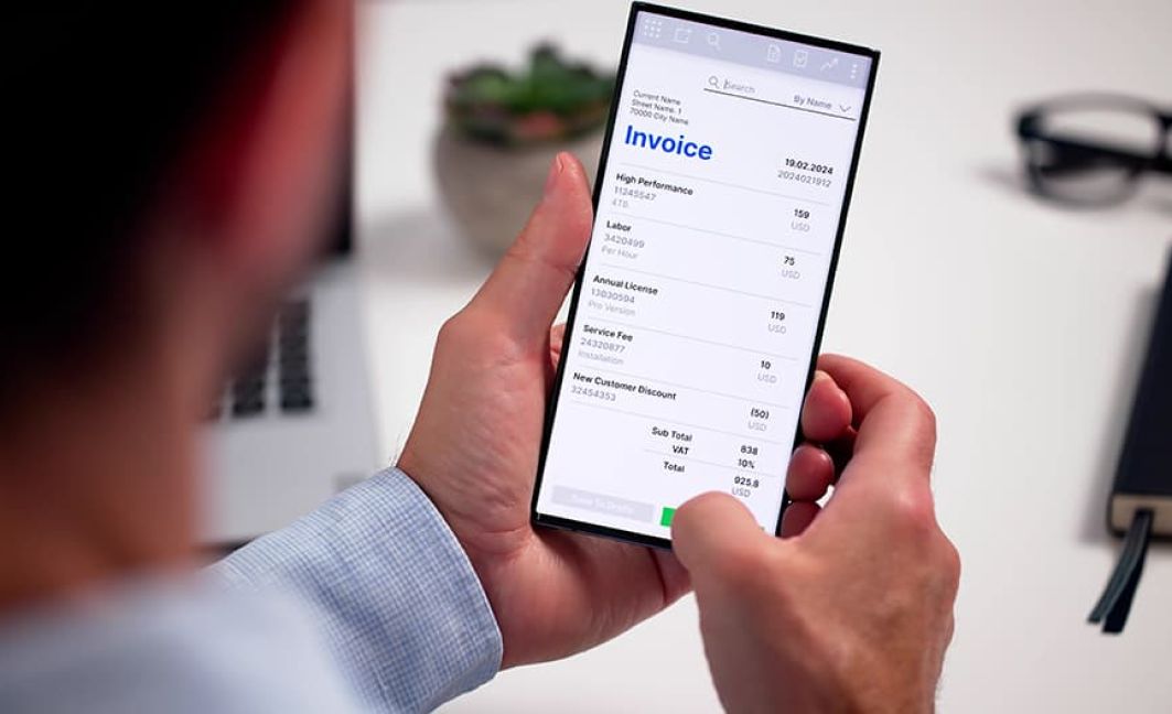 man holding iphone to create invoice