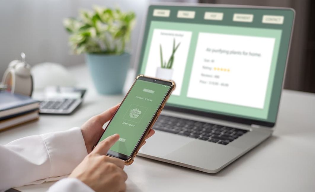 Woman on phone and laptop making purchases with customized payment links