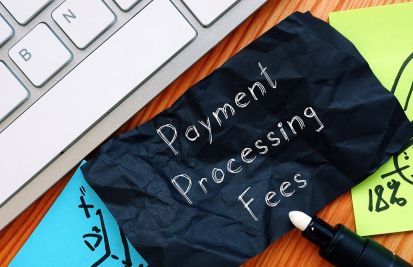 payment processing fees on paper next to laptop