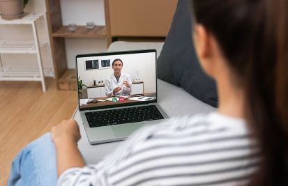 Patient on a laptop having a telehealth call with a doctor
