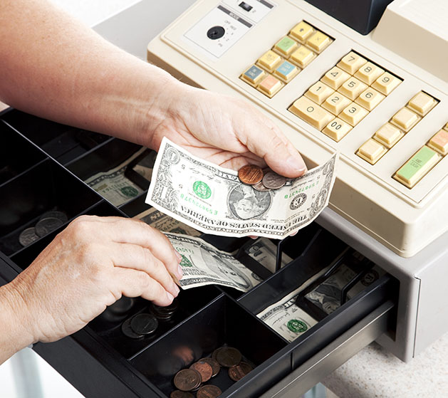 Hands taking money out of a register