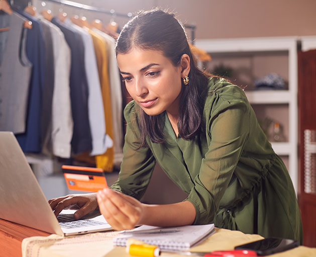 A woman using omnichannel payment processing systems from North to pay for inventory on her laptop