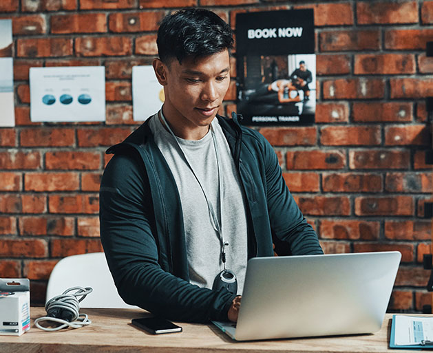 A fitness club manager analyzing customer loyalty on a laptop