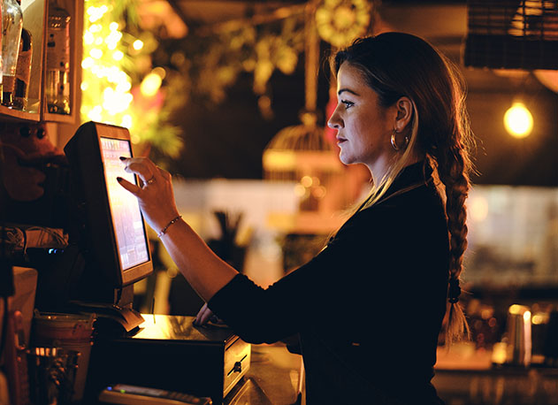 A bar hostess closing out a tab using North POS software