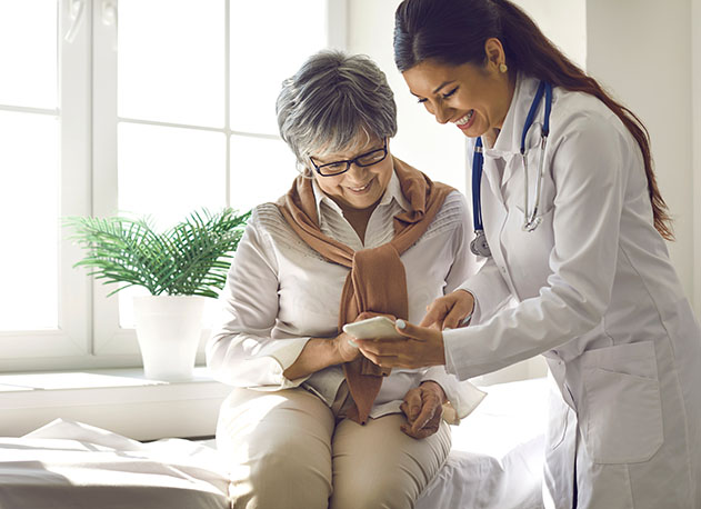 A healthcare professional helping an adult patient looking at a mobile payment terminal