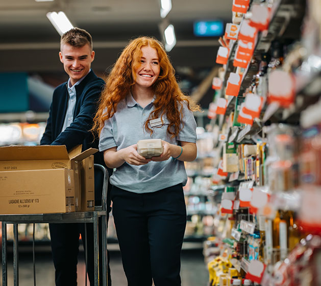 A woman placing products on a shelf, content knowing she has superior inventory management thanks to North