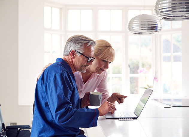 An older couple reviewing their online perscription information on a laptop