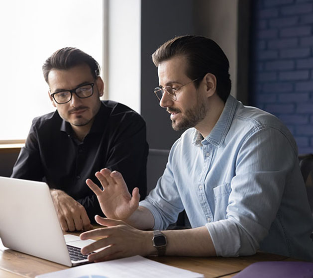 Two men at a laptop discussing North's intergraded payment processing systems