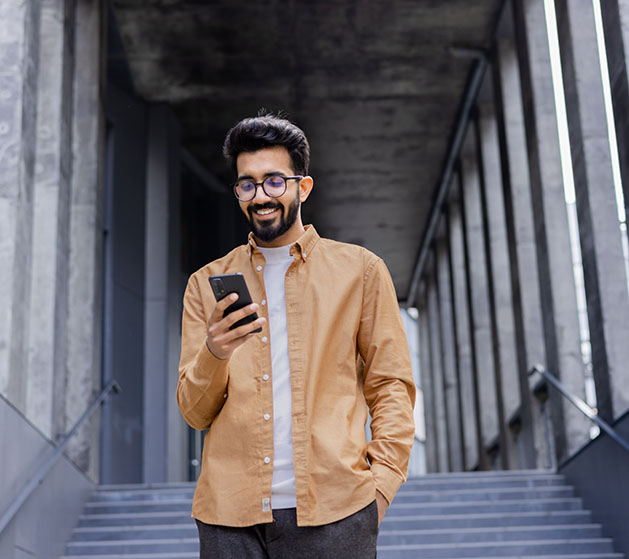 A man review sales reports on his phone while walking outside 