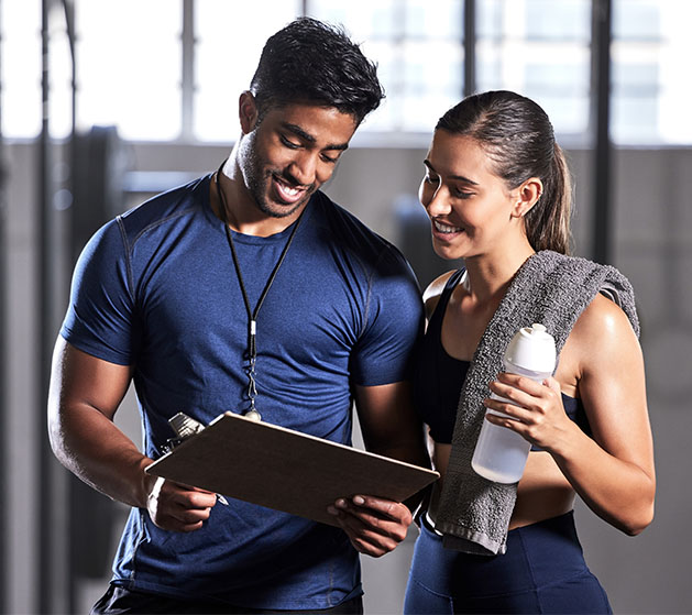 A personal trainer in a gym showing a guest how to use contactless payments