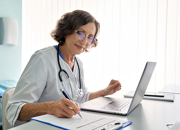 A doctor taking down notes while on a telemedicine call